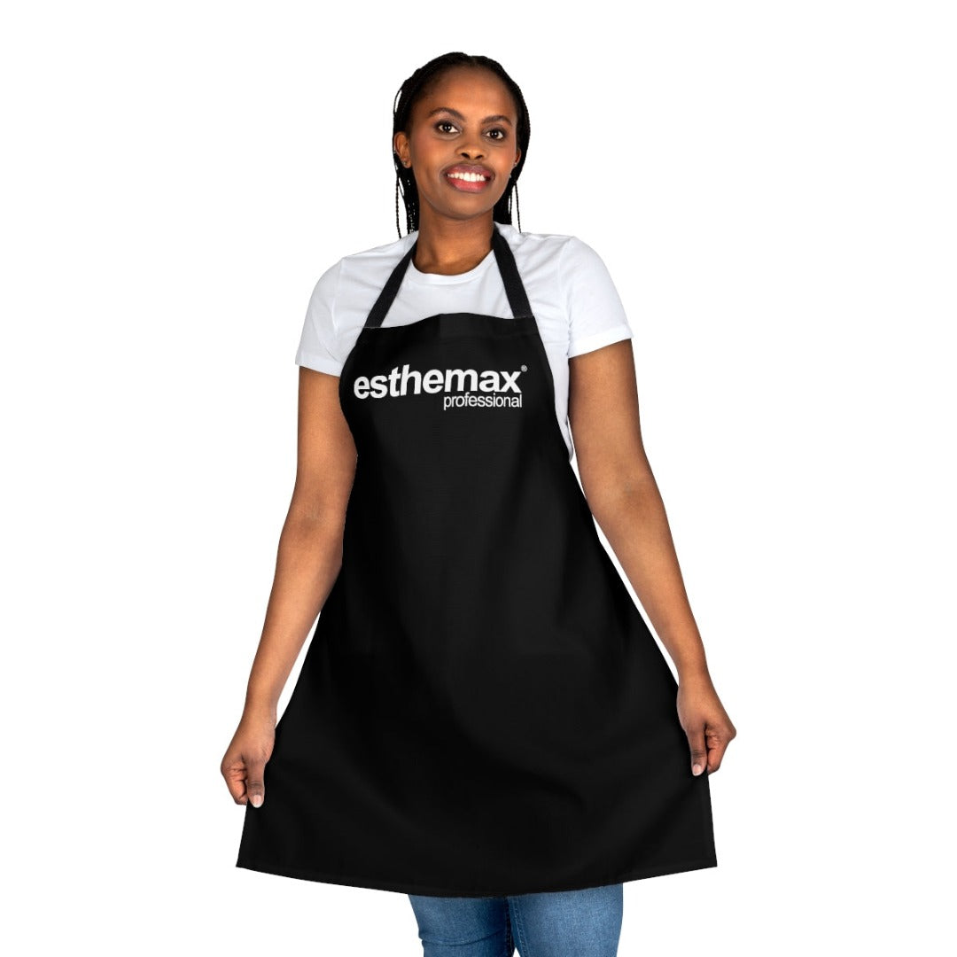 A woman wearing a black coloured 100% polyester canvas Esthemax Clinic Apron on a white background, on Spa Circle Brands product listing page.