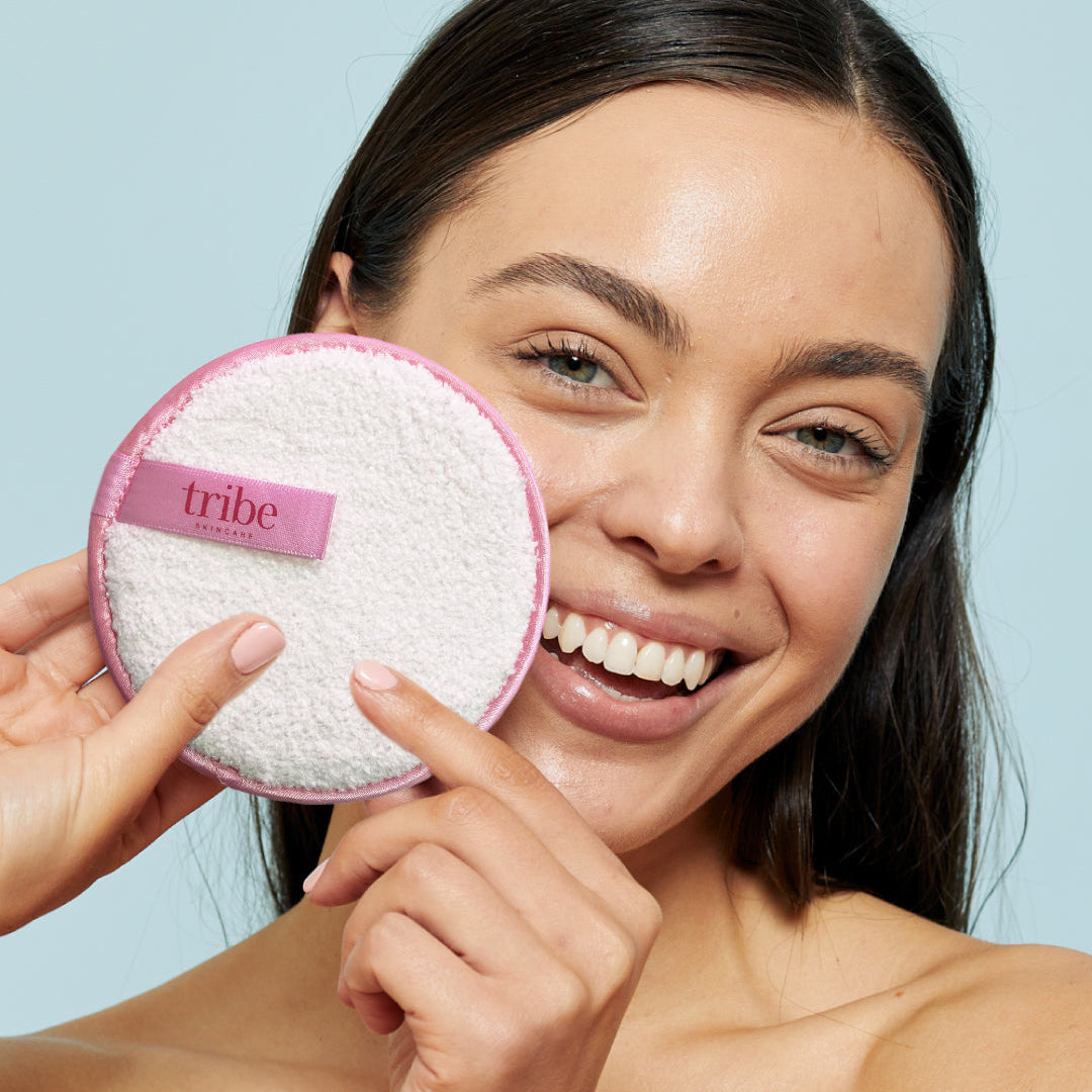 Woman holding Tribe Makeup Removal Mitt in front of her, showcased on Spa Circle Brands' product listing.