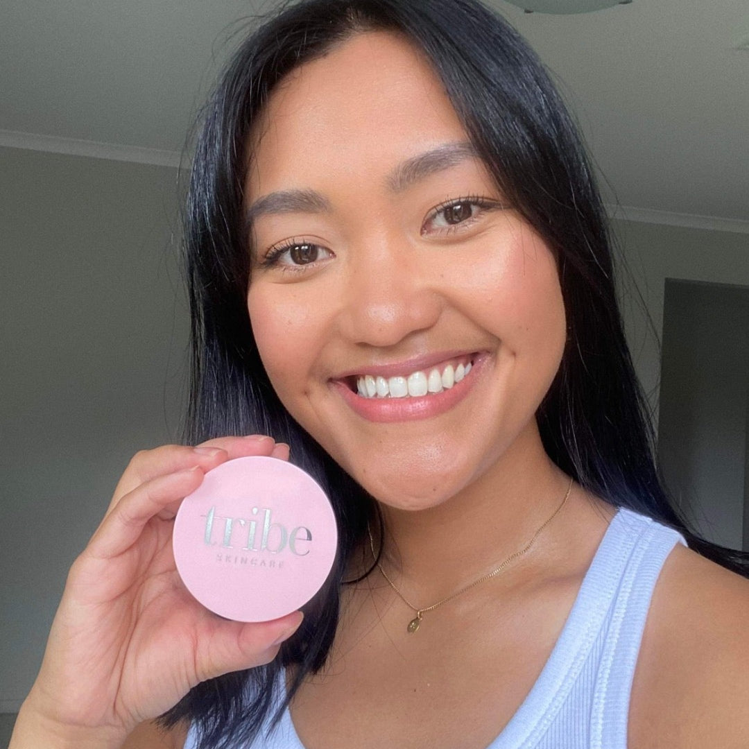A young confident woman showcasing her face with the full coverage of Tribe Mineral Makeup Powder TAN, featured on Spa Circle Brands' product listing.