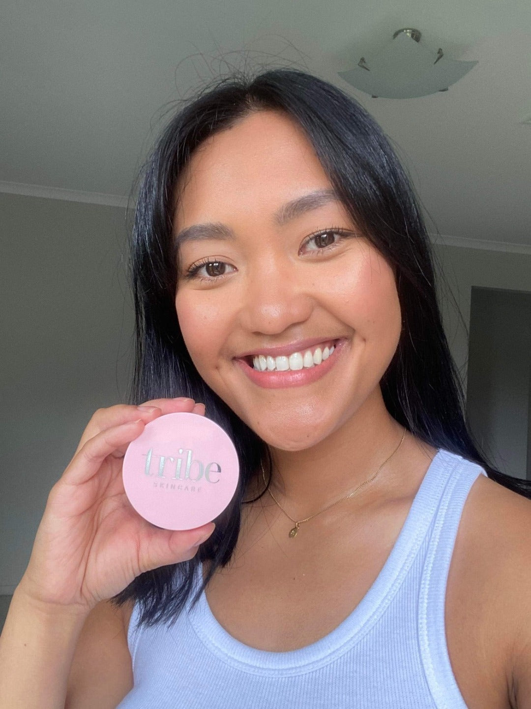 A young confident woman showcasing her face with the full coverage of Tribe Mineral Makeup Powder TAN, featured on Spa Circle Brands' product listing.