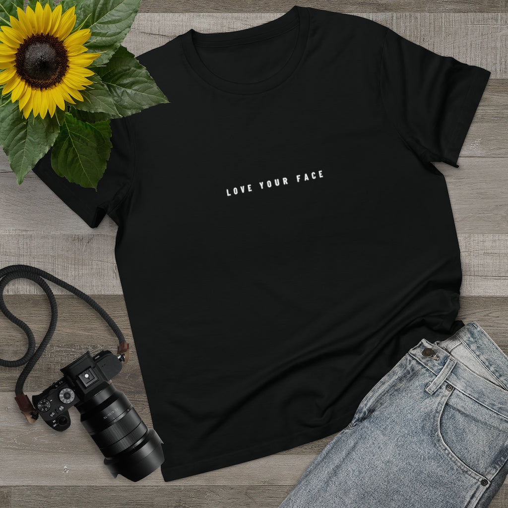 A black t-shirt with a love your skin design on it beside the jeans, camera, andsunflower, on Spa Circle Brands product listing page.